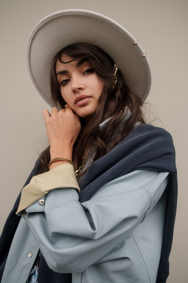 girl wearing cream colored hat and soft blue clothing