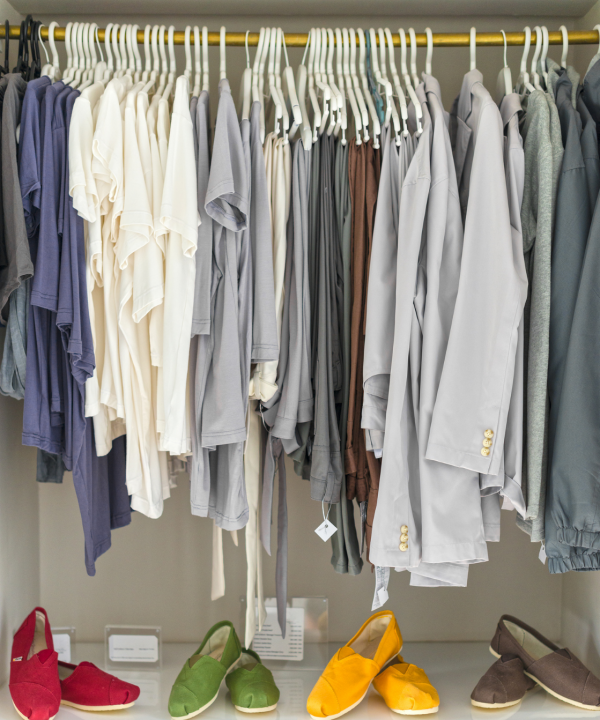 a closet rack with womens clothing in light colors