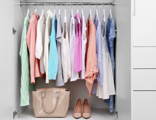 pastel colored women's wardrobe on clothing rack